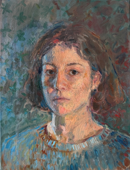 A girl looking directly at us. Her hair, jumper and the background blend together with her face standing out in contrast.